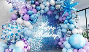 Frozen birthday decoration ideas at home with blue balloon arch winter wonderland backdrop and snowflake decorations